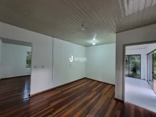 Ambiente interno com piso de madeira e paredes brancas.