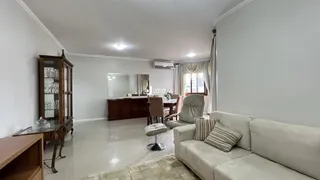 Sala de estar com sofá e móveis de madeira clara em um imóvel no Brasil.