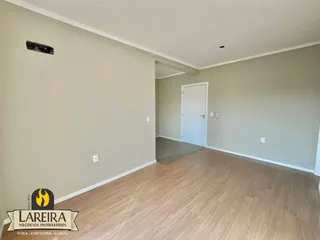 Ambiente interno com piso de madeira clara e paredes bege.