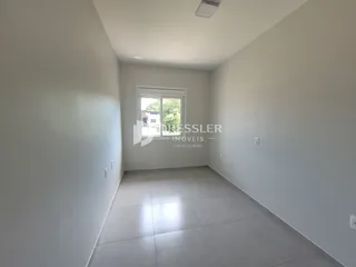 Vista interna de um cômodo com paredes brancas e piso claro.