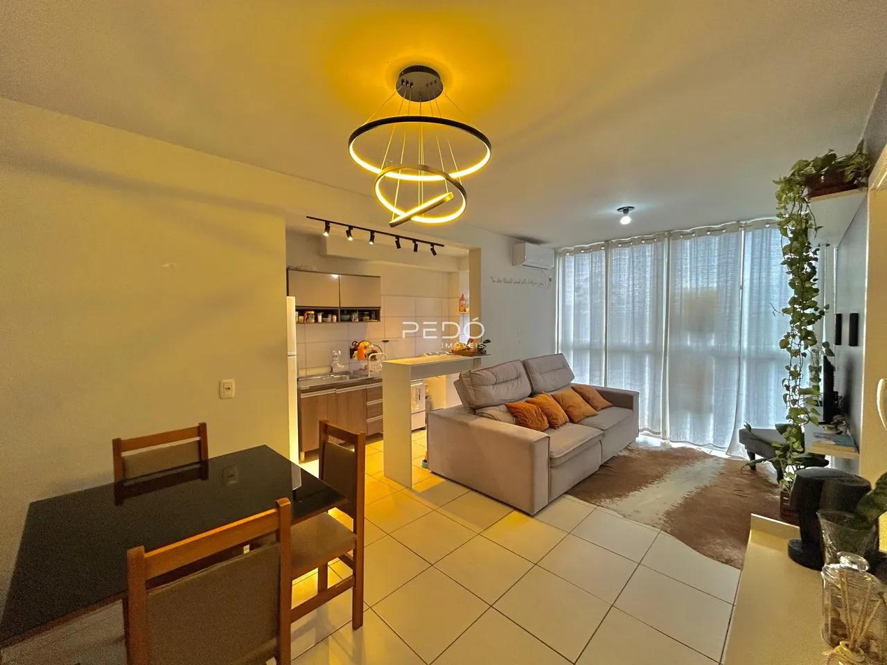 Sala de estar com decoração moderna e grandes janelas em um imóvel no Brasil.