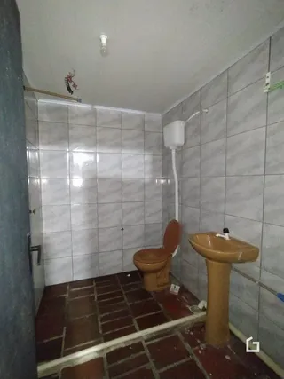 Foto do interior de um banheiro com revestimento de azulejos brancos.