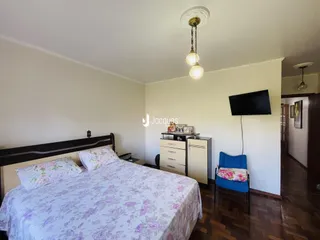 Quarto com cama e televisão em um ambiente interno.