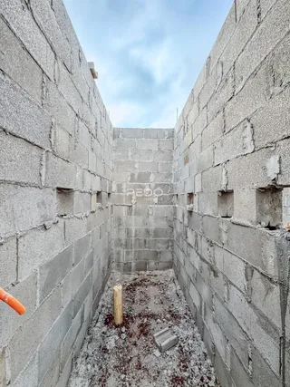Corredor interno de uma estrutura de concreto em construção.