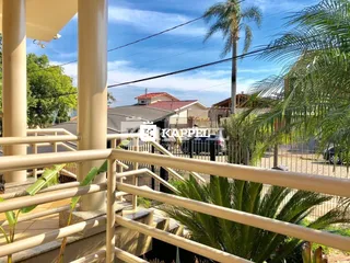 Vista da varanda com vegetação tropical e paisagem ao fundo.