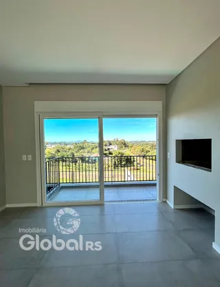 Sala de estar com vista para o exterior através de portas de vidro.