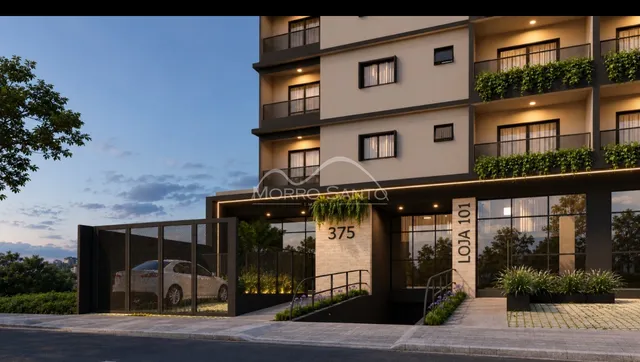Fachada moderna de um edifício residencial em Lajeado, Brasil, com área de estacionamento e paisagismo.