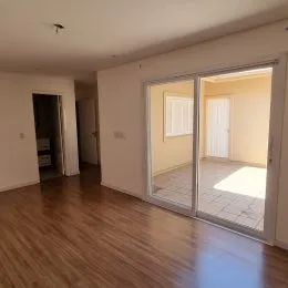 Interior com piso de madeira e portas de acesso em uma residência.