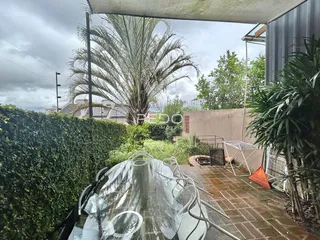 Área externa com paisagismo e mesa de jantar em um imóvel no Brasil.