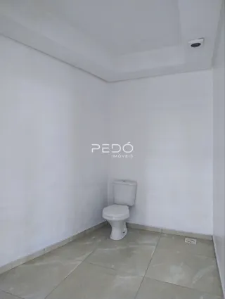 Foto interna de um banheiro com piso de cerâmica e paredes brancas.