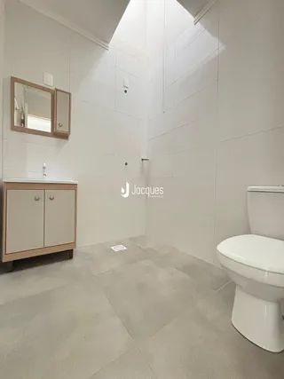Foto de um banheiro moderno com revestimento branco e piso cinza claro.