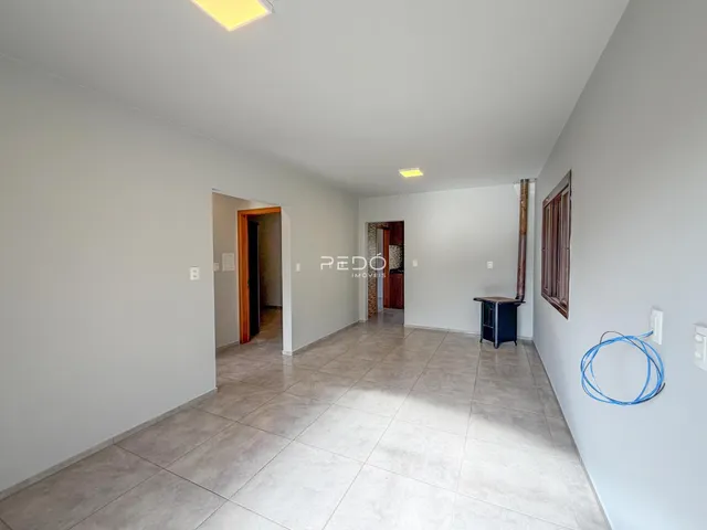Corredor interno de uma residência com piso de cerâmica clara.