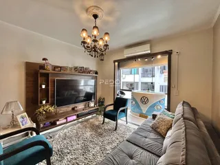 Sala de estar com sofá e televisão em um ambiente interno.