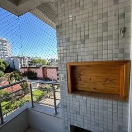 Vista de um terraço com parede de azulejos brancos.