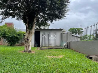 Fachada de uma residência com jardim gramado e cerca de metal.