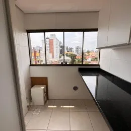 Foto de uma cozinha com armários brancos e piso de cerâmica.
