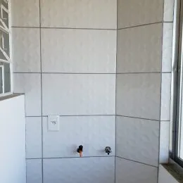 Parede interna com revestimento em painéis brancos e cinzas.