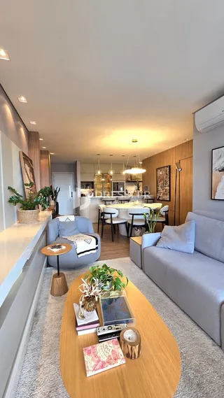 Sala de estar e jantar moderna com piso de madeira clara.