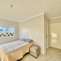 Quarto com cama e janela em ambiente interno.