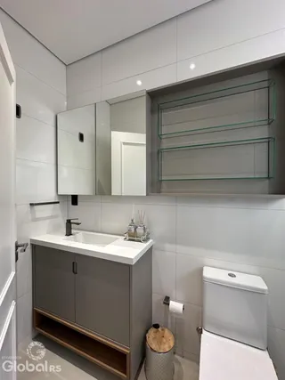 Foto de um banheiro com revestimento branco e bancada moderna.