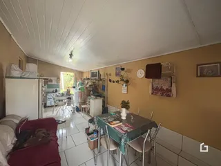 Ambiente interno de uma sala de estar com área de jantar e cozinha em Lajeado.