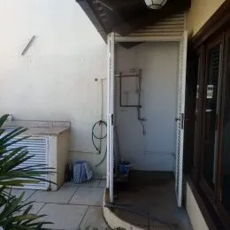 Hall de entrada com parede branca e porta.