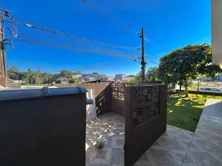 Vista externa de um quintal com cerca de madeira e piso de cerâmica.