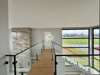 Escadaria com guarda-corpo de vidro em um interior moderno.