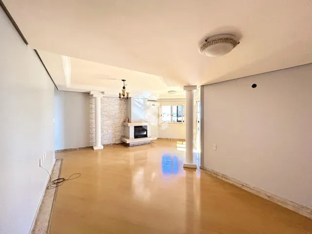 Ambiente interno de uma sala ampla com piso de mármore claro e paredes brancas.