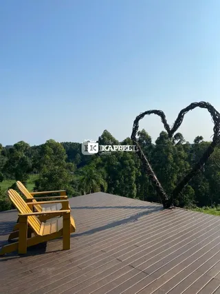 Deck de madeira com espreguiçadeiras em um ambiente externo.