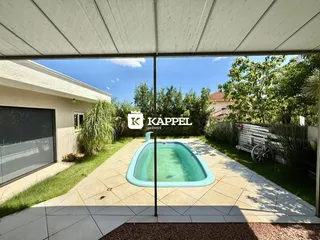 Foto de uma piscina externa em um terreno com vegetação.