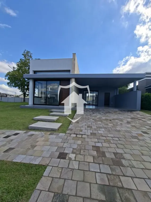 Fachada moderna de uma residência em Lajeado, Brasil, com jardim e área pavimentada.