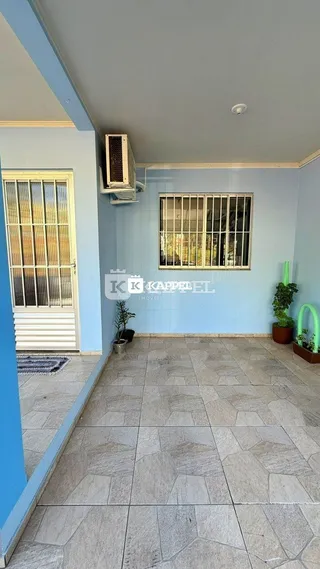 Hall de entrada com paredes azuis claras e piso de cerâmica.