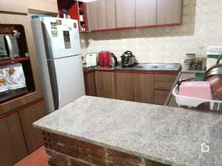 Cozinha com armários de madeira e bancada de granito.