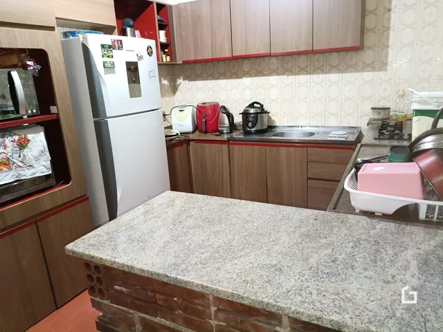 Cozinha com armários de madeira e bancada de granito.