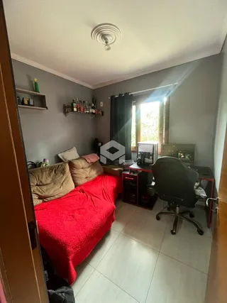 Foto de um quarto com cama vermelha e área de trabalho.