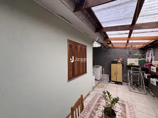 Parede interna com porta de madeira e teto de estrutura de madeira exposta.