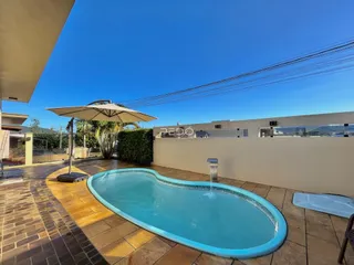 Piscina externa com deck e muro em Lajeado.