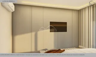 Interior de um quarto com cabeceira e televisão de tela plana em um ambiente moderno.