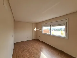 Quarto com piso de madeira e janela.