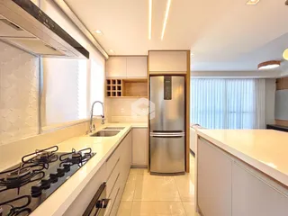 Esta é uma foto de uma cozinha moderna com armários brancos e bancadas claras.