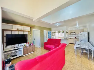 Sala de estar com sofá vermelho e móveis de madeira em um apartamento no Brasil.