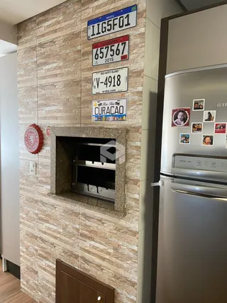 Parede revestida com azulejos marrons e nicho de pedra na decoração interna.