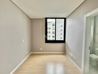 Ambiente interno com piso de madeira clara e janela.