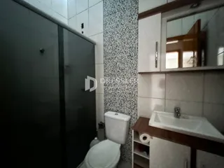 Foto de um banheiro com azulejos e um vaso sanitário.