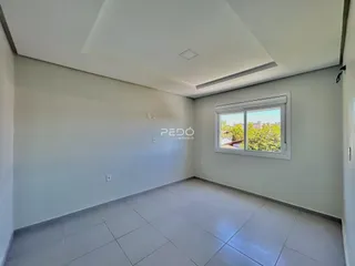 Ambiente interno de uma sala com piso de cerâmica e paredes brancas.