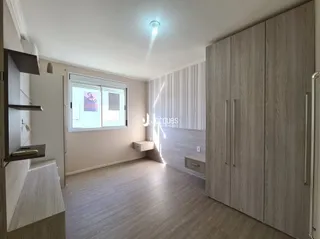 Quarto com armários embutidos e piso de madeira clara.