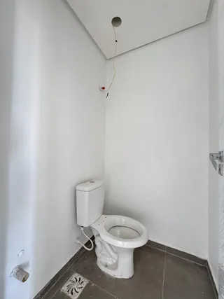 Foto de um banheiro simples com vaso sanitário e piso de cerâmica.