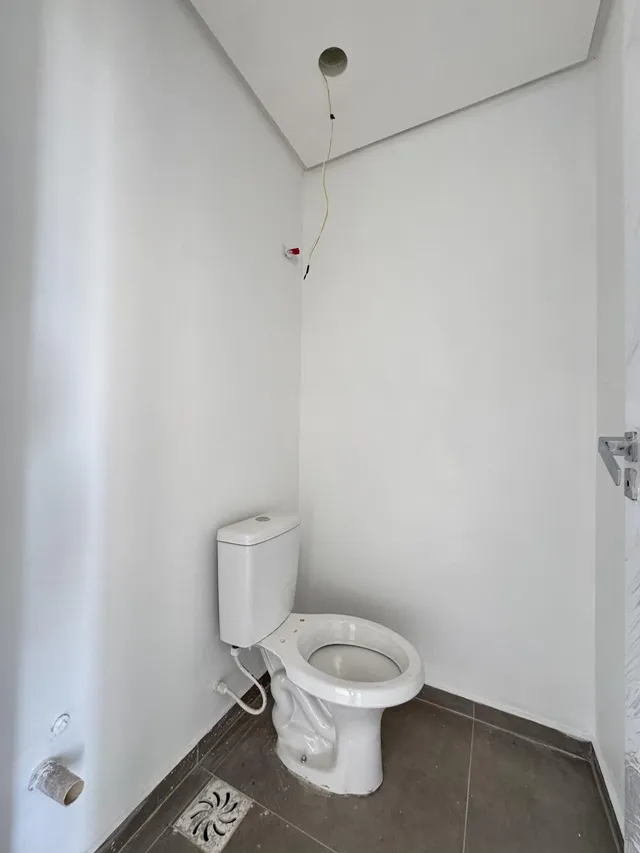 Foto de um banheiro simples com vaso sanitário e piso de cerâmica.