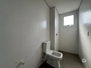 Banheiro com paredes brancas e piso claro.